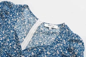 Detailansicht von Karree-Ausschnitt mit Reißverschluss an blumig bedrucktem Kleid