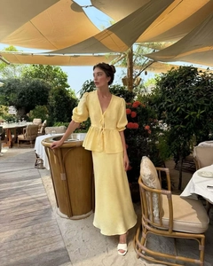 Detailed texture of yellow puff sleeve top and high-waist skirt in breathable linen fabric