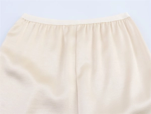 Detail of elastic waist on light beige embroidered skirt with a silky texture and drape