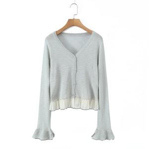 Light gray knit cardigan with V-neck and white chiffon ruffled trim on wooden hanger