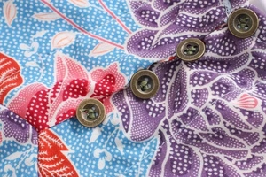 Gros plan d'une robe en coton à fleurs avec boutons en bronze vintage et couture fine