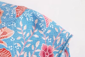 Close-up of blue floral shirt fabric with pink flower prints and white polka dots