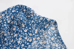 Detailansicht des blauen Blumenkleides mit Falten an der Schulter und Blumenmuster