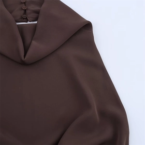 Detail of high-neck draped collar with three back buttons on a brown satin dress