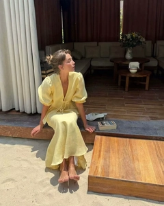 Detail of French style pale yellow dress featuring puff sleeves and tie-up V-neckline