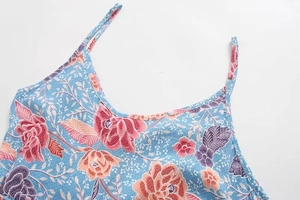 Détail de l'encolure et de l'imprimé floral sur le tissu d'une robe d'été bleu clair