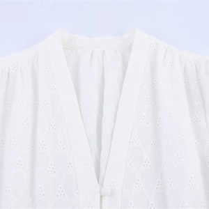 White V-neck dress featuring delicate eyelet embroidery and a covered button detail