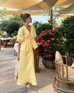 Detail of light yellow summer set showing linen texture and puff sleeves in outdoor setting