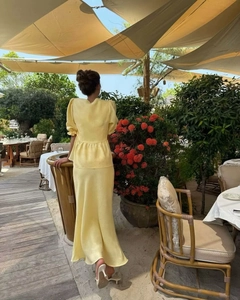 Detail view of yellow two-piece set with puff sleeves and mermaid skirt in garden setting