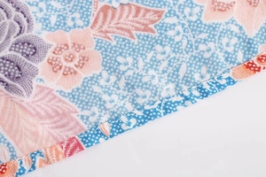 Macro shot of ethnic floral batik pattern on rayon fabric with reinforced edge stitching
