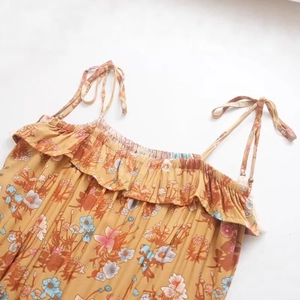 Floral print summer dress with ruffled neckline and adjustable tie-straps in yellow