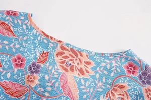 Close-up of crew neckline on a blue floral cotton shirt with boho flower patterns