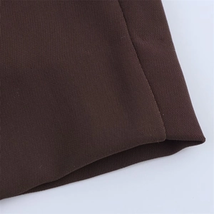 Close-up detail of dark brown twill fabric with smooth stitching and fine texture