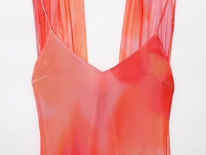 Détail du tissu en maille dégradé orange et rose avec une texture marbrée fine