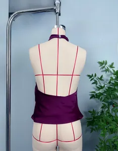 Dettaglio posteriore di un top in raso viola scuro con scollatura all'americana e lacci