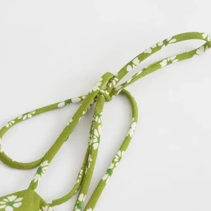 Green daisy print summer dress featuring delicate spaghetti straps and crepe fabric texture