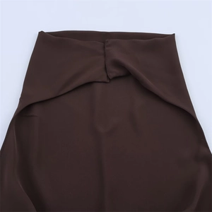 Detail view of deep brown halter dress showing overlapping pleated waist design