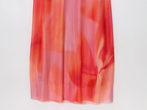 Vue détaillée du tissu en maille dégradé rose et orange montrant la texture légère