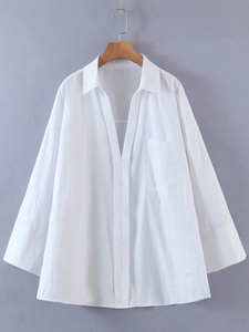 Makroansicht der weißen Oversized-Baumwollbluse mit Brusttasche und Kragendetails