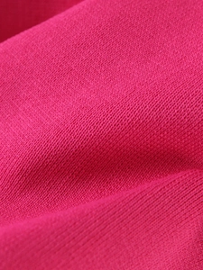 Macro shot of hot pink ribbed knit fabric showing fine stitching and elastic texture