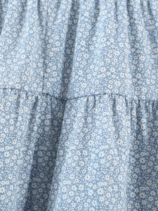 Détail du tissu floral bleu clair avec volants froncés et délicat imprimé fleuri blanc