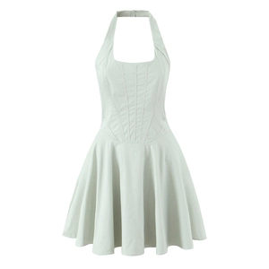 Détail d'une robe dos nu vert menthe avec coutures corset et jupe plissée