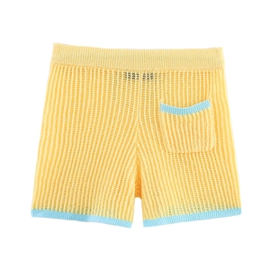 Détail du short en maille jaune clair avec bordure contrastée bleu clair