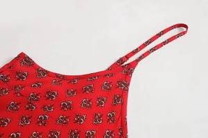 Detail of adjustable spaghetti strap on red floral print dress with fine stitching