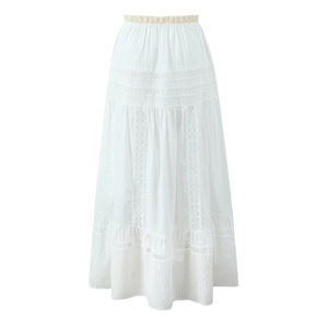 Detailed macro view of white tiered skirt with intricate lace embroidery and fabric texture