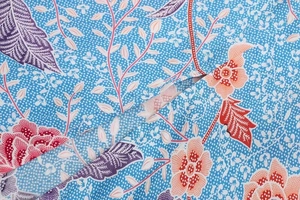 Detail of blue floral batik fabric with red and purple flowers for high-split skirt