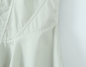 Détail de la couture double et de la taille incurvée de cette élégante robe