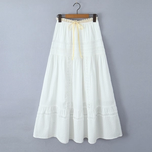 Detail of white cotton maxi skirt with elastic waist, yellow ribbon and lace tiers