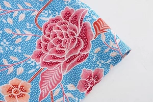 Detail of light blue skirt with pink floral print and white polka dot texture