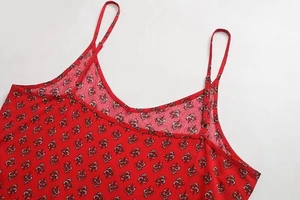 Detail view of red floral summer dress with V-neckline and adjustable spaghetti straps