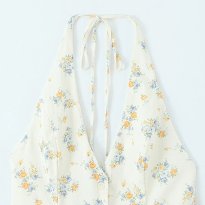 Detail of floral halter neck top featuring yellow and blue blossoms with button closure