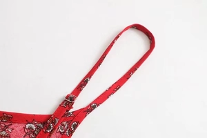 Detail of red floral dress showing adjustable spaghetti strap and silver metal buckle