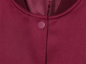 Detail der weinroten Jacke mit Rippstrickkragen, mattem Knopf und glattem Satinfutter