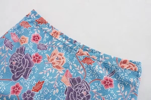 Detailed macro view of invisible zipper closure and floral print on light blue skirt fabric