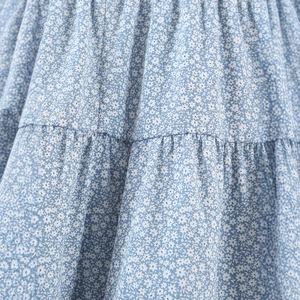 Robe d'été à fleurs bleu clair avec imprimé blanc et détails plissés élégants
