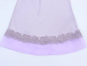 Detailed view of lavender satin skirt hem with floral embroidery and organza trim