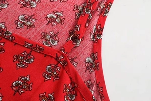 Detailed macro view of the red floral print fabric with metal ring strap connector