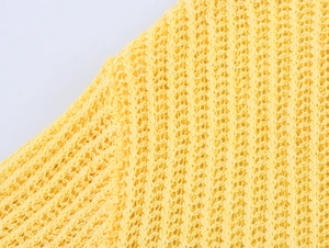 Gros plan détaillé du tissu en maille jaune vif montrant la texture ajourée du polo