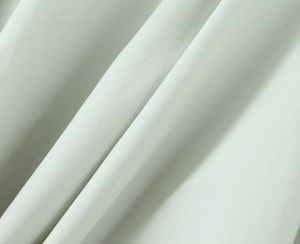 Vue macro détaillée de la texture du tissu vert sauge clair avec un tissage uni fin et mat