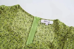 Close-up of the invisible back zipper and floral fabric detail on this green dress