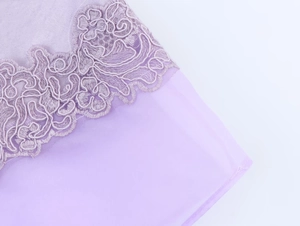 Detailed view of lavender satin organza skirt showing delicate floral embroidery and lace
