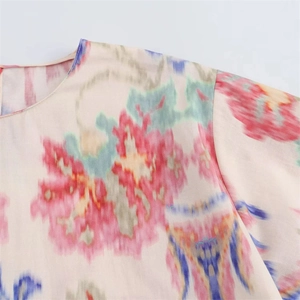 Detailed close-up of vibrant abstract floral print on women's crew neck summer top fabric