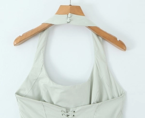 Détail de robe dos nu vert clair avec col à bouton, dos croisé et fermeture éclair invisible