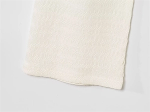 Détail d'un ensemble blanc décontracté avec texture gaufrée et finitions de couture nettes