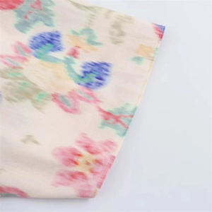 Detailed macro view of colorful floral print and neat hem stitching on woven fabric