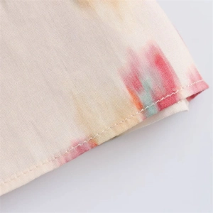 Detail of single-stitch hem on floral print cotton fabric with watercolor patterns